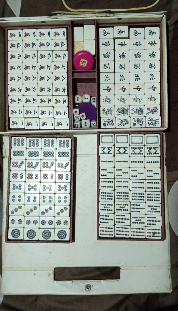 Vintage Mahjong Set with Case and Accessories (Category: Board Games & Puzzles) located in Manila. Submitted by superbass1982 (Listing ID 1464524580, Image 3). Description: - Complete vintage Mahjong set - Includes all tiles, dice, and accessories - Tiles made of durable material - Case features a 'KKK' emblem - Case shows some signs of wear but is fully functional - Great for game nights and Mahjong enthusiasts.
