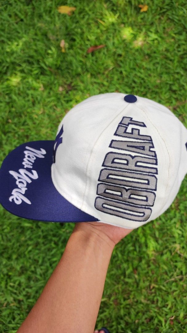 Vintage New York Yankees 'OB DRAFT' Snapback Cap (Category: Caps & Hats) located in Malungon. Submitted by marmar0303 (Listing ID 1464373473, Image 2). Description: - White and navy New York Yankees snapback cap - 'New York' script on the brim - 'OB DRAFT' text on the sides and back - Classic Yankees logo on the front - Adjustable snapback closure - Perfect for any Yankees fan!.