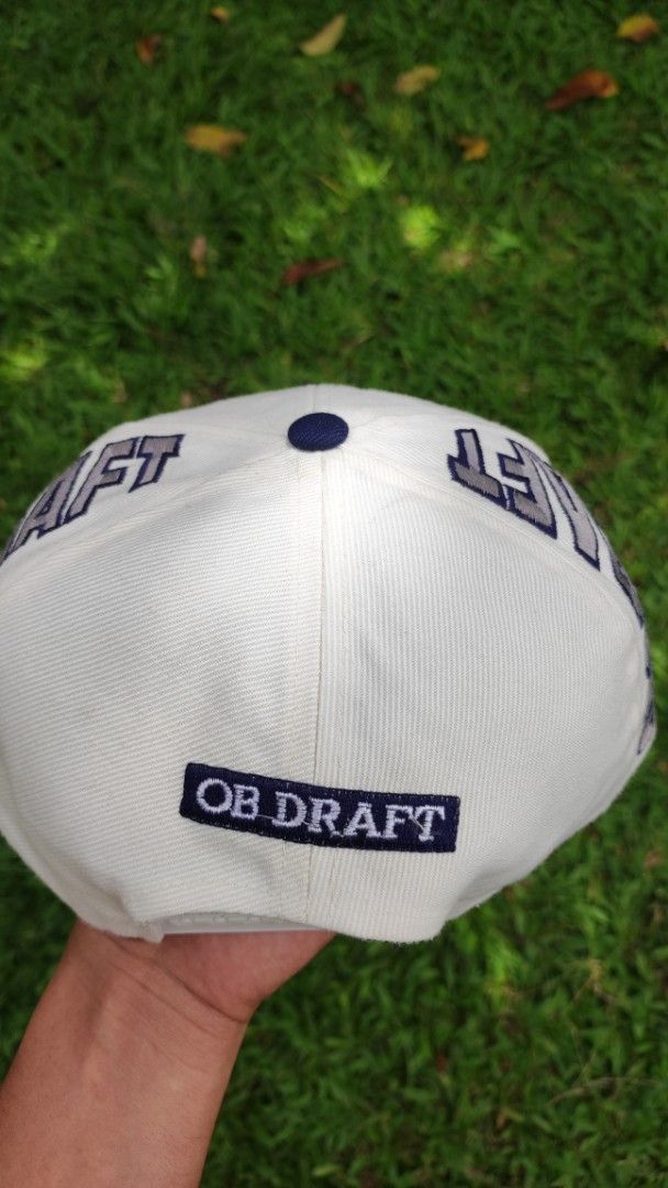 Vintage New York Yankees 'OB DRAFT' Snapback Cap (Category: Caps & Hats) located in Malungon. Submitted by marmar0303 (Listing ID 1464373473, Image 3). Description: - White and navy New York Yankees snapback cap - 'New York' script on the brim - 'OB DRAFT' text on the sides and back - Classic Yankees logo on the front - Adjustable snapback closure - Perfect for any Yankees fan!.