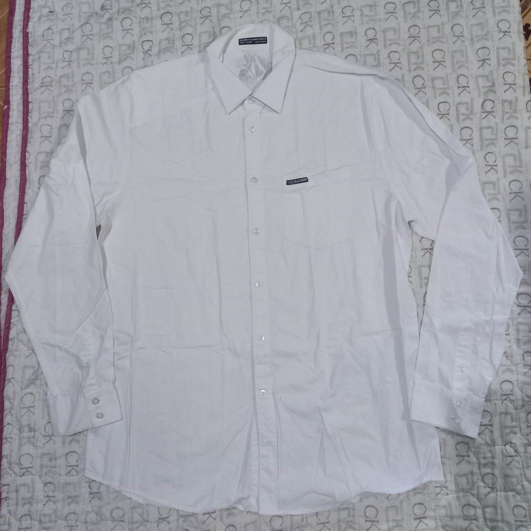 Volcom Tailored White Long Sleeve Shirt X-Large (Category: Tshirts & Polo Shirts ) located in Baguio. Submitted by jiannisthriftfits (Listing ID 1464566560, Image 1). Description: - White Volcom tailored long sleeve shirt - Size: X-Large - Made in Macau - Features a small Volcom logo on the chest pocket - Button-up front - Versatile for casual or smart casual occasions.