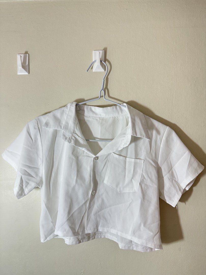 White Cropped Button-Up Shirt with Pocket (Category: Shirts) located in Baguio. Submitted by archivedbyj (Listing ID 1464389959, Image 1). Description: - White cropped shirt - Short sleeves - Features a collar - Button-up front - Single chest pocket - Lightweight, slightly crinkled fabric - Ideal for casual outfits or layering.