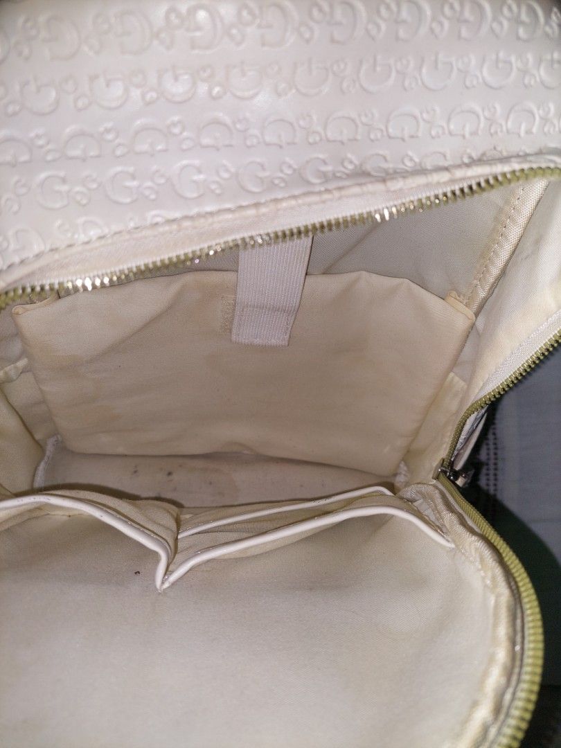 White Guess Backpack with Embossed Gs (Category: Backpacks) located in Manila. Submitted by okeanos (Listing ID 1464365407, Image 3). Description: - White Guess backpack - All-over embossed G pattern - Front pocket with zip and Guess logo stripe - Gold hardware - Adjustable straps - Minor marks on the bag.