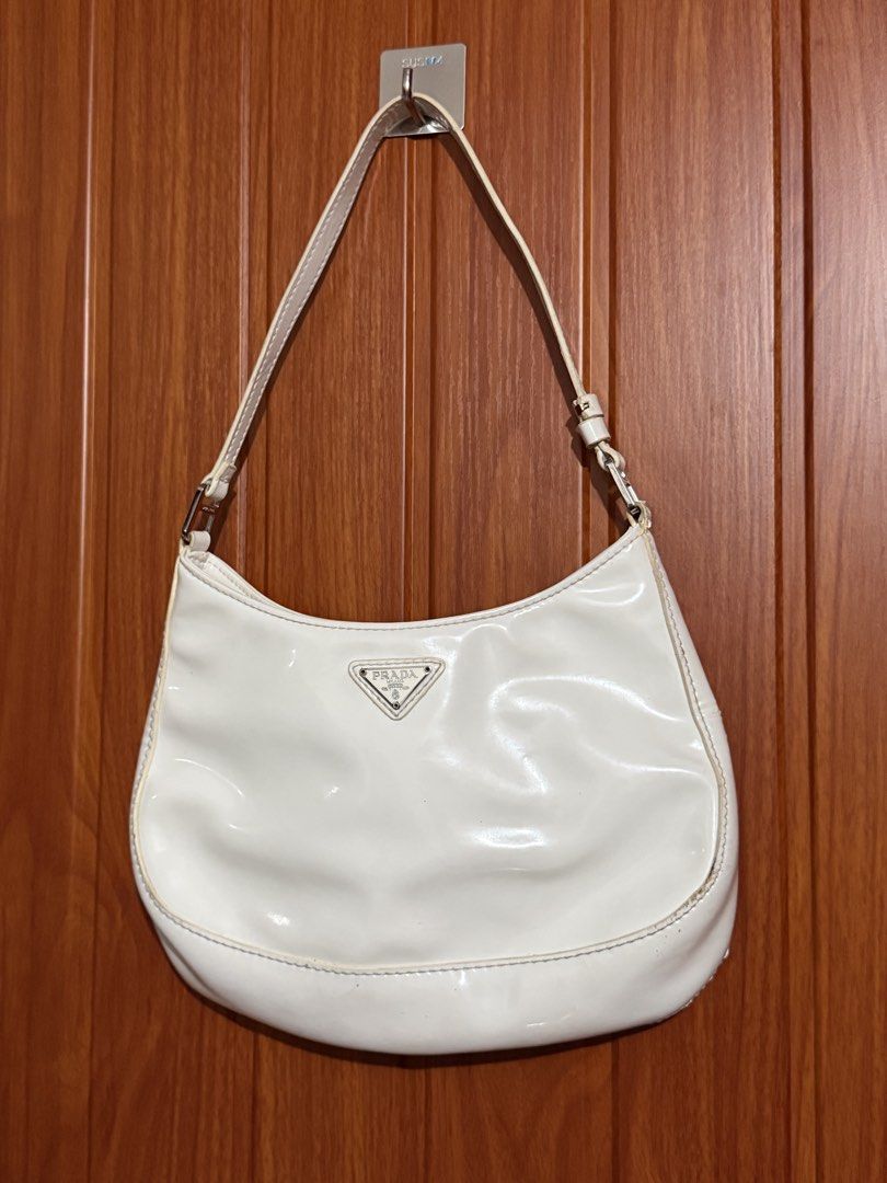White Patent Leather Prada Shoulder Bag (Category: Luxury Bags & Wallets) located in Manila. Submitted by tlfph (Listing ID 1464540787, Image 2). Description: - Authentic white patent leather Prada shoulder bag - Elegant silver hardware details - Spotless interior for a pristine look - Timeless shoulder bag design, ideal for everyday style - Shows some gentle wear on edges and strap, adding character.