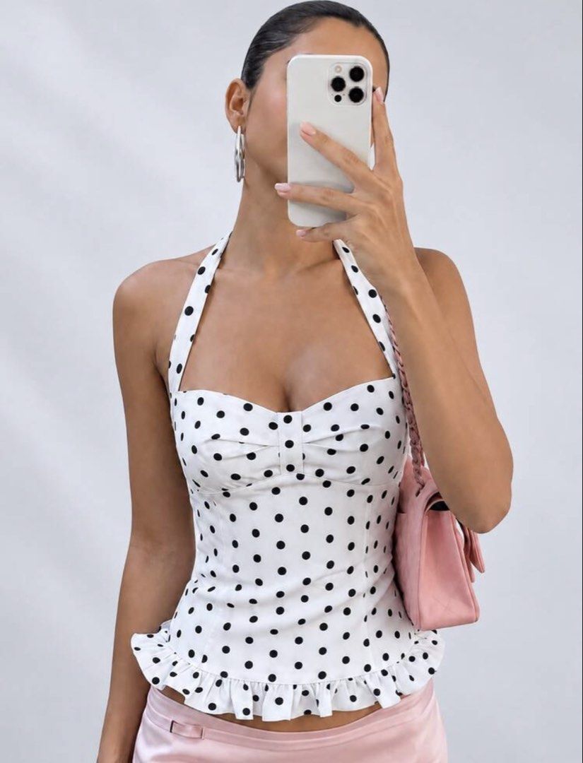 White Polka Dot Halter Neck Top with Ruffle Hem (Category: Sleeveless) located in Mandaluyong City. Submitted by prettyfindsbyb (Listing ID 1464496056, Image 1). Description: - DM for when worn! - Super cute white halter top - Black polka dot pattern - Sweetheart neckline - Ruffled hem detail - Ties at the neck with a bow - Flattering fit - Versatile: great with jeans or skirts - Ideal for summer days or a night out.