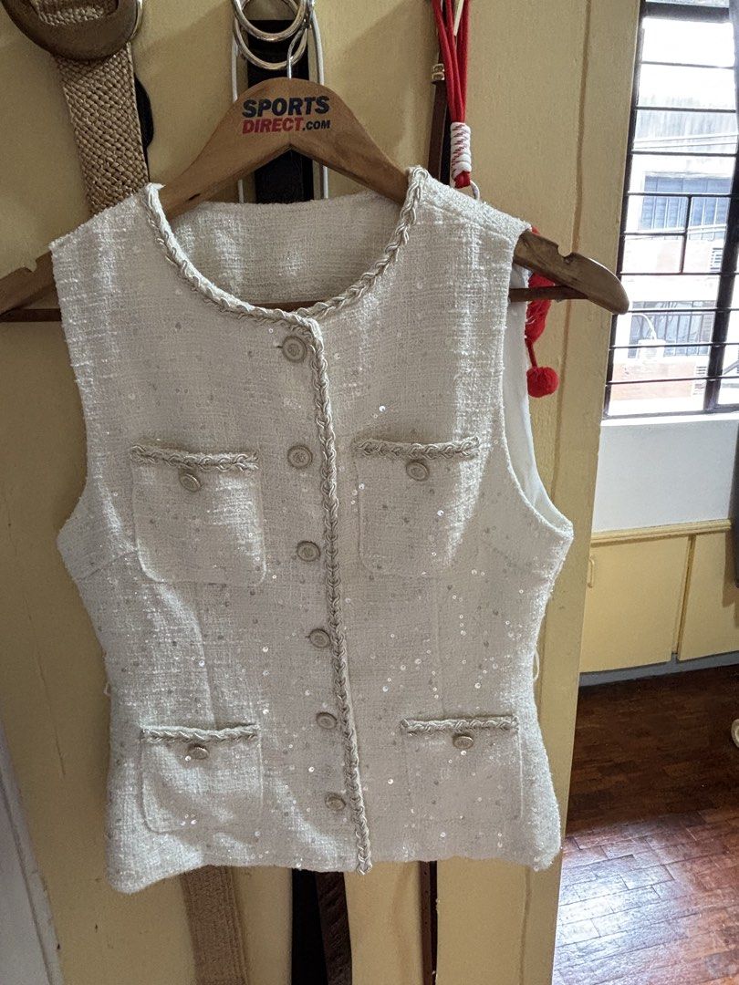 White Sequin Tweed Vest with Pearl Buttons (Category: Sleeveless) located in Manila. Submitted by haydee008 (Listing ID 1464391869, Image 1). Description: - White sleeveless vest - Textured tweed fabric with all-over sequins - Decorative pockets and braided trim - Button-up front with pearl-like buttons - Versatile for layering over tops or dresses.