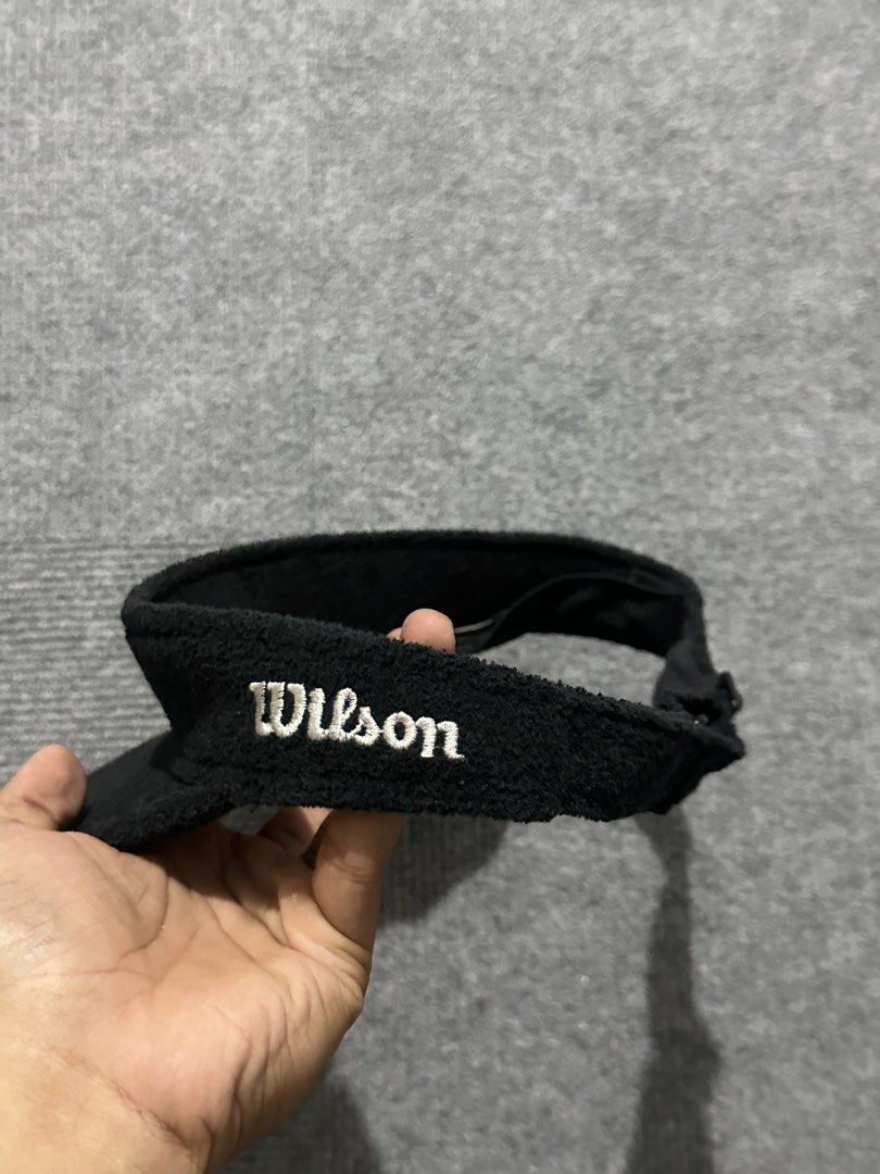 Wilson Black Terry Cloth Visor (Category: Caps & Hats) located in Villasis. Submitted by justinramosonfb (Listing ID 1464469575, Image 2). Description: - Black terry cloth visor by Wilson - Features embroidered 'W' logo on front - 'Wilson' embroidered on the side - Adjustable strap for a custom fit - Ideal for sports and everyday casual wear.
