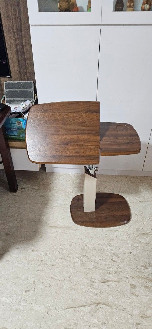Versatile Adjustable Side Table (Category: Tables & Sets) located in Singapore. Submitted by ah_kher (Listing ID 1464472919, Image 2). Description: Versatile Adjustable Side Table • Suitable for use beside a sofa/couch or as a bedside table • 360° rotating tabletop for flexible positioning • One side of the tabletop can be tilted, allowing you to adjust the angle Suitable for use with laptops, books, meals, or other items while sitting on the sof