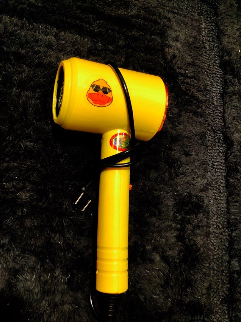 Yellow Duck Hair Dryer (Category: Hair) located in Lucena. Submitted by box_it (Listing ID 1464442190, Image 1). Description: - Adorable yellow hair dryer with a cute duck sticker - Compact and ideal for travel or as a vanity accessory - Features a black cord with a standard plug - Convenient cord wrap for easy storage - Offers multiple heat settings for versatile styling.