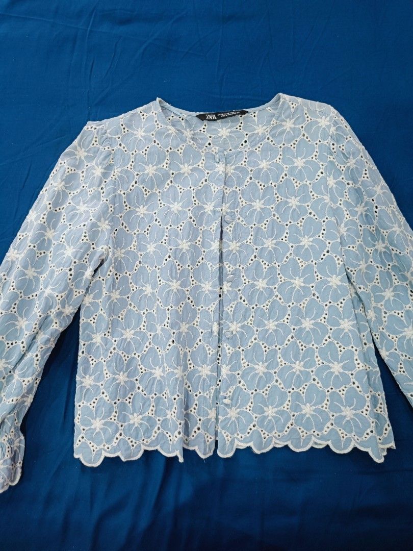 Zara Blue Eyelet Embroidered Button-Up Blouse (Category: Blouses) located in Manila. Submitted by jpsal (Listing ID 1464360208, Image 2). Description: - Zara light blue blouse - never used - Intricate white eyelet embroidery all over (floral pattern) - Button-up front - Scalloped hem and cuffs - Long sleeves with gathered wrist detail - Made in Indonesia.