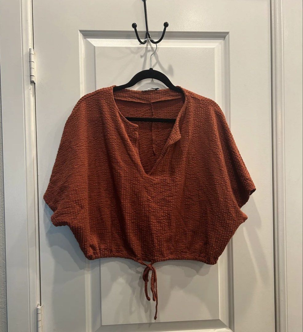 ZARA Textured Cropped Top with Drawstring (Category: Sleeveless) located in Batangas. Submitted by kulilayfinds (Listing ID 1464362342, Image 2). Description: - Rust-colored cropped top from ZARA - Textured waffle-like material - V-neck with a small slit - Adjustable drawstring at the hem - Short, dolman-style sleeves - Made in Turkey - Ideal for casual wear.