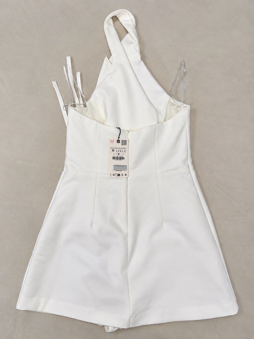 Zara White Dress (Category: Dresses) located in Manila. Submitted by marieladea47607 (Listing ID 1464461534, Image 2). Description: - White halter neck dress from Zara - Wrap style with tie closure - Collared neckline, sleeveless design - Can be worn as a mini dress or long top - Size: Medium (M) - Brand new with original tags attached, bought for 3,395.