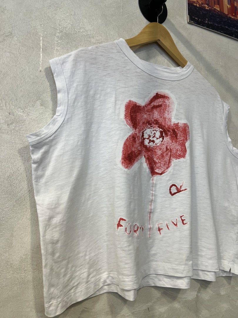 45 rpm box type flower sketch print (Category: Others Tops) located in Manila. Submitted by -handpick- (Listing ID 1464696707, Image 3). Description: Boxy sleeveless top from the Japanese clothing brand 45R (45rpm). The piece showcases their signature hand-drawn style, displaying a prominent red flower sketch alongside the handwritten text “FORTY-FIVE” and the recognizable “R” logo emblem. Size : 0 Dimensions : Length : 22 inches Width : 25 inche