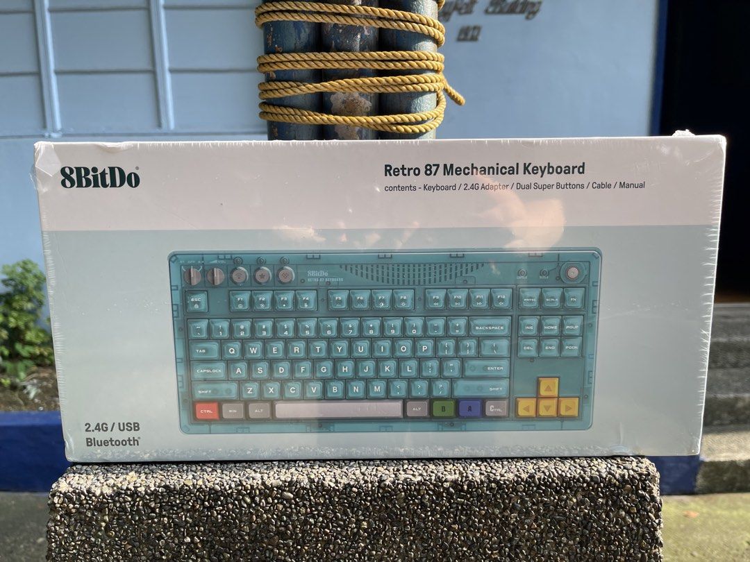 8BitDo Retro 87 Mechanical Keyboard (Category: Computer Keyboard) located in Quezon City. Submitted by mdtabbott (Listing ID 1464690922, Image 1). Description: - Item: 8BitDo Retro 87 Mechanical Keyboard - Condition: Brand new, unopened in original plastic wrap - Connectivity: 2.4G wireless, USB wired, and Bluetooth - Design: Blue-green transparent chassis with multi-colored bottom row keys and yellow directional arrows - Inclusions: Keyboard, 2.