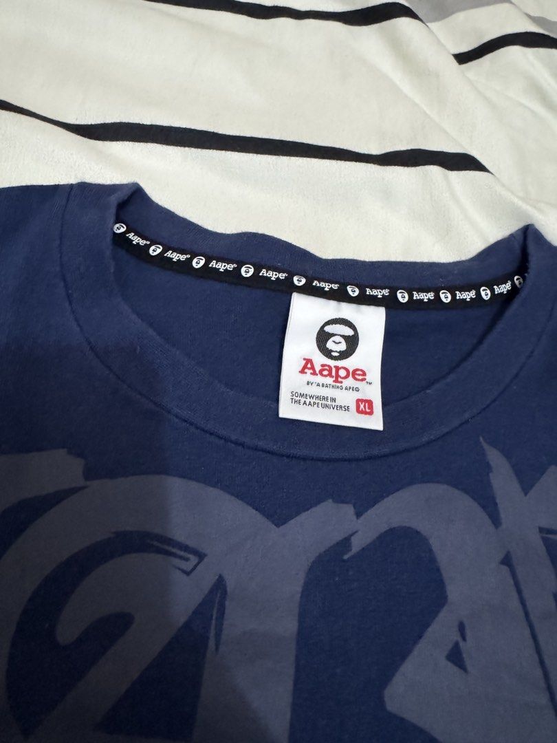 A Bathing Ape Aape Navy Camo Patchwork T-Shirt XL (Category: Tshirts & Polo Shirts ) located in Bulacan. Submitted by alshopie (Listing ID 1464608677, Image 3). Description: - Navy blue Aape t-shirt - Size XL - Cool patchwork design - Features iconic ape head logo - Includes camo print accents - Made of 100% cotton - Please check photos for detailed condition.