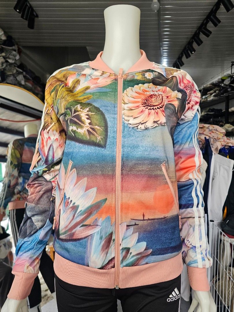 Adidas Curso d'Agua Superstar Track Jacket (Category: Coats, Jackets and Outerwear) located in Baguio. Submitted by kayeonlineshop (Listing ID 1464660034, Image 2). Description: -Features a vibrant all-over floral and water lily print inspired by Brazilian landscapes, complemented by a soft pink front zipper and ribbed collar, cuffs, and hem. -Measurements includes in the photos.
