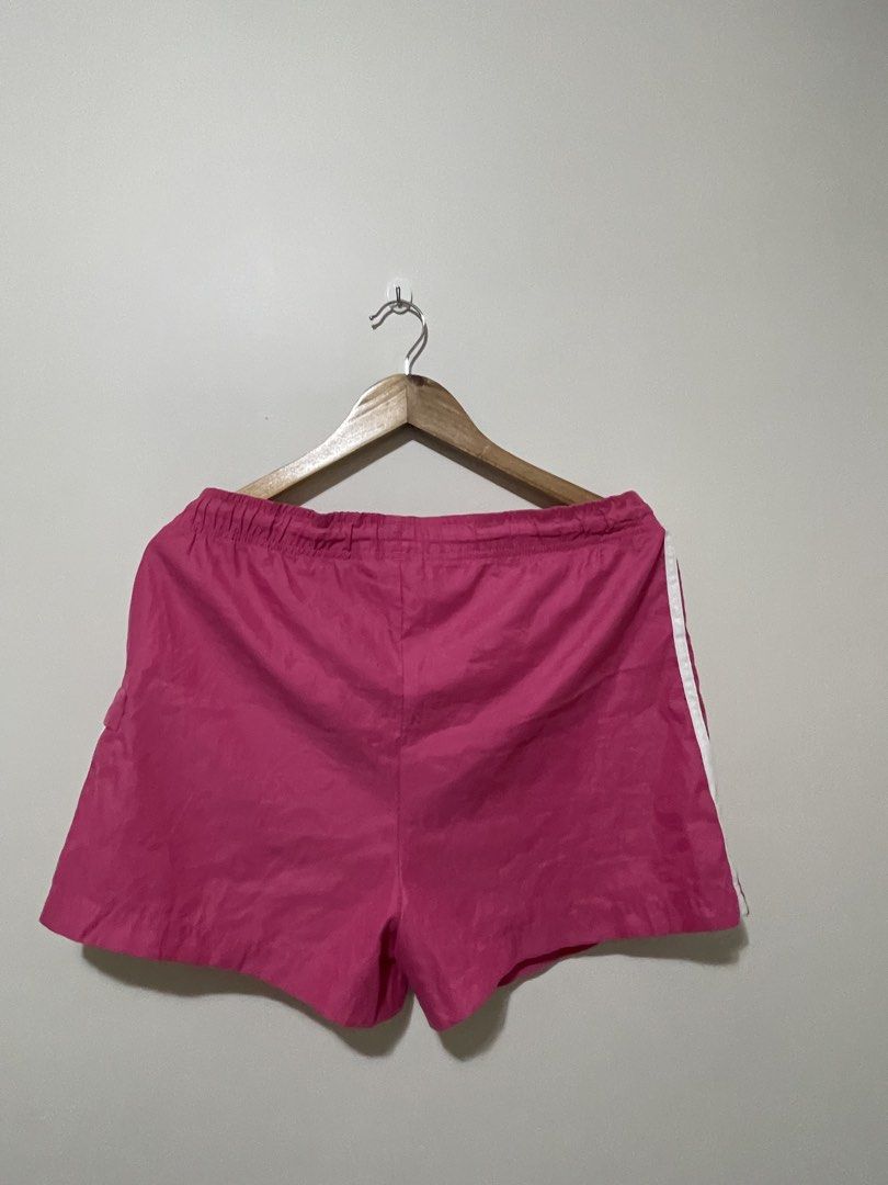 Adidas Pink Shorts with White Stripes (Category: Shorts) located in Pasig City. Submitted by gespinosa (Listing ID 1464737216, Image 2). Description: - Brand: Adidas - Color: Vibrant pink with white three stripes - Size: USA Medium - Material: Lightweight nylon - Features: Elastic waistband with adjustable pink drawstrings, side pocket with tab closure, and small logo on lower left leg - Condition: Clean interior tags intact - Best for: Workouts 