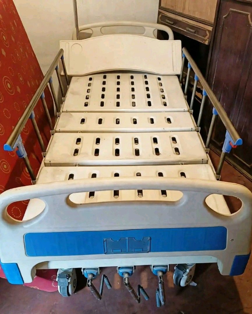 Adjustable Hospital Bed with Mattress and Side Rails (Category: Bed Frames & Mattresses) located in Mandaluyong City. Submitted by quickmountain.780662 (Listing ID 1464581449, Image 1). Description: - Adjustable hospital bed - Safety side rails included - Comes with a red patterned mattress - White and blue bed frame - Equipped with wheels for easy mobility - Features multiple adjustable sections - Suitable for home care or medical facilities - 3
