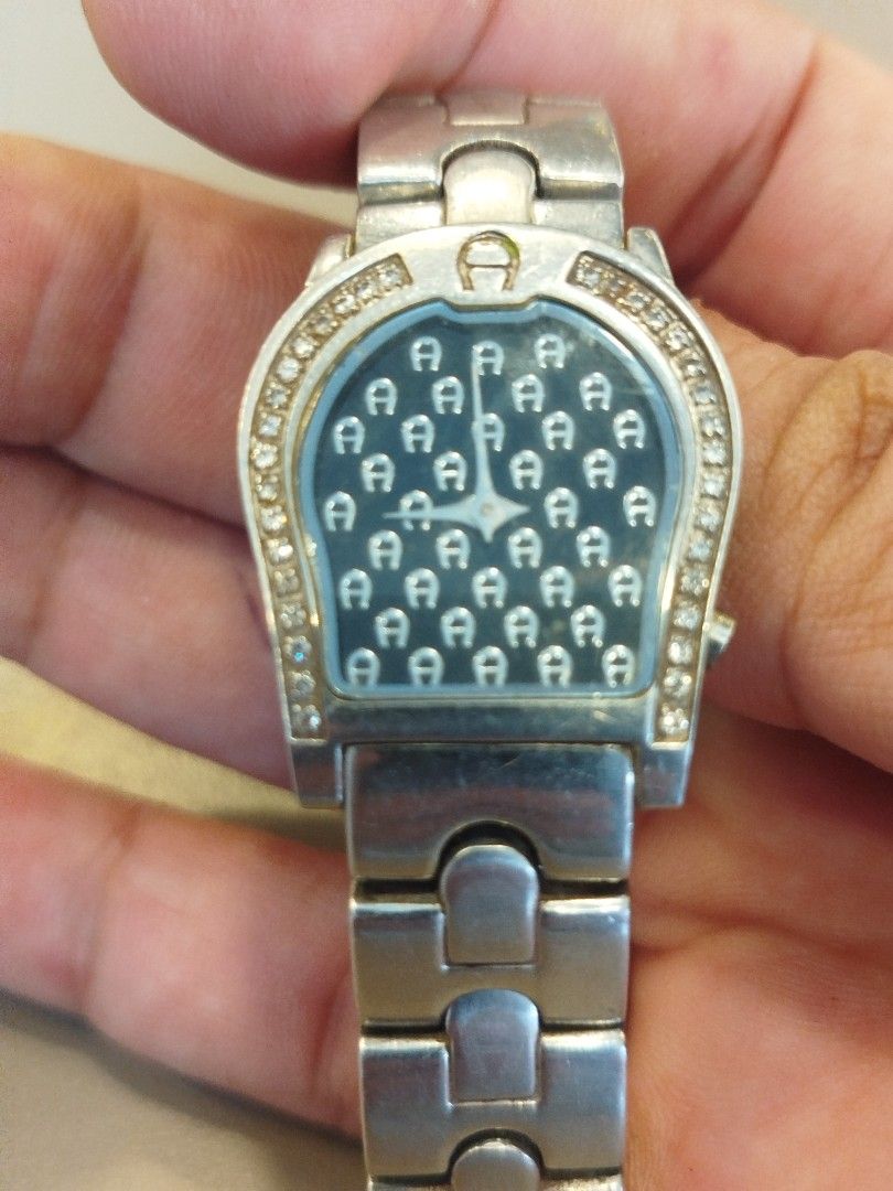 Aigner Diamond Bezel Watch (Category: Women's Watches) located in Subic. Submitted by regiedaniel01 (Listing ID 1464574235, Image 2). Description: - not Authentic silver Aigner watch - Striking black dial with repeating Aigner logo pattern - Luxurious diamond bezel for added sparkle - Durable and stylish silver metal watch band - Classic, versatile timepiece suitable for both casual and formal wear.