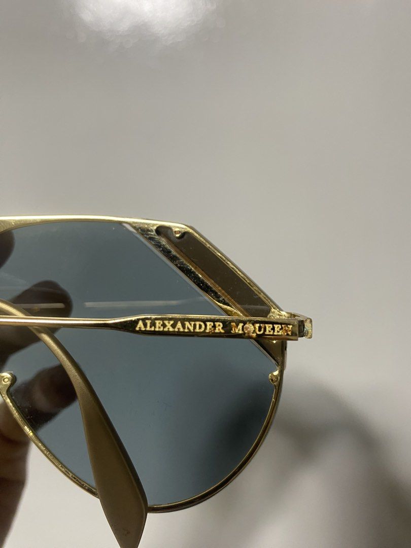 Alexander McQueen Gold Aviator Sunglasses (Category: Sunglasses & Eyewear) located in Pasacao. Submitted by wengpullar37205 (Listing ID 1464745434, Image 3). Description: - Brand: Alexander McQueen - Style: Aviator sunglasses with geometric brow bar - Frame: Gold-tone metal with crystal detailing on top corners - Lenses: Dark blue - Details: Brand name stamped on temples, adjustable nose pads included - Condition: Classic statement piece with min