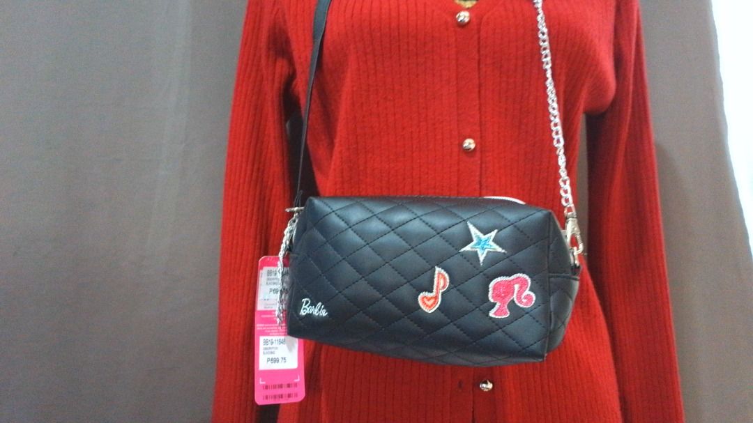 Authentic Barbie Quilted Black Crossbody Bag (Category: Cross-body Bags) located in Caloocan City. Submitted by 11eleven.shop (Listing ID 1464583970, Image 2). Description: - Cute black quilted crossbody bag - Adorned with fun Barbie graphic charms (star, music note) - Interior lining features a cool Barbie print - Equipped with a stylish chain strap (adjustable) - Secure zip closure - Perfect gift for any Barbie enthusiast!.