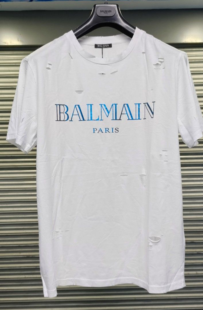 Balmain Paris White Distressed Logo T-Shirt (Category: Tshirts & Polo Shirts ) located in Zamboanga. Submitted by benbryanab14320 (Listing ID 1464644959, Image 1). Description: - Authentic Balmain Paris white t-shirt - Features iconic blue Balmain Paris logo - Stylish distressed details all over - Size: Large (L) - Origin: Made in PRC - Care Instructions: Hand wash separately inside out. Do not bleach or tumble dry. -Unisex.