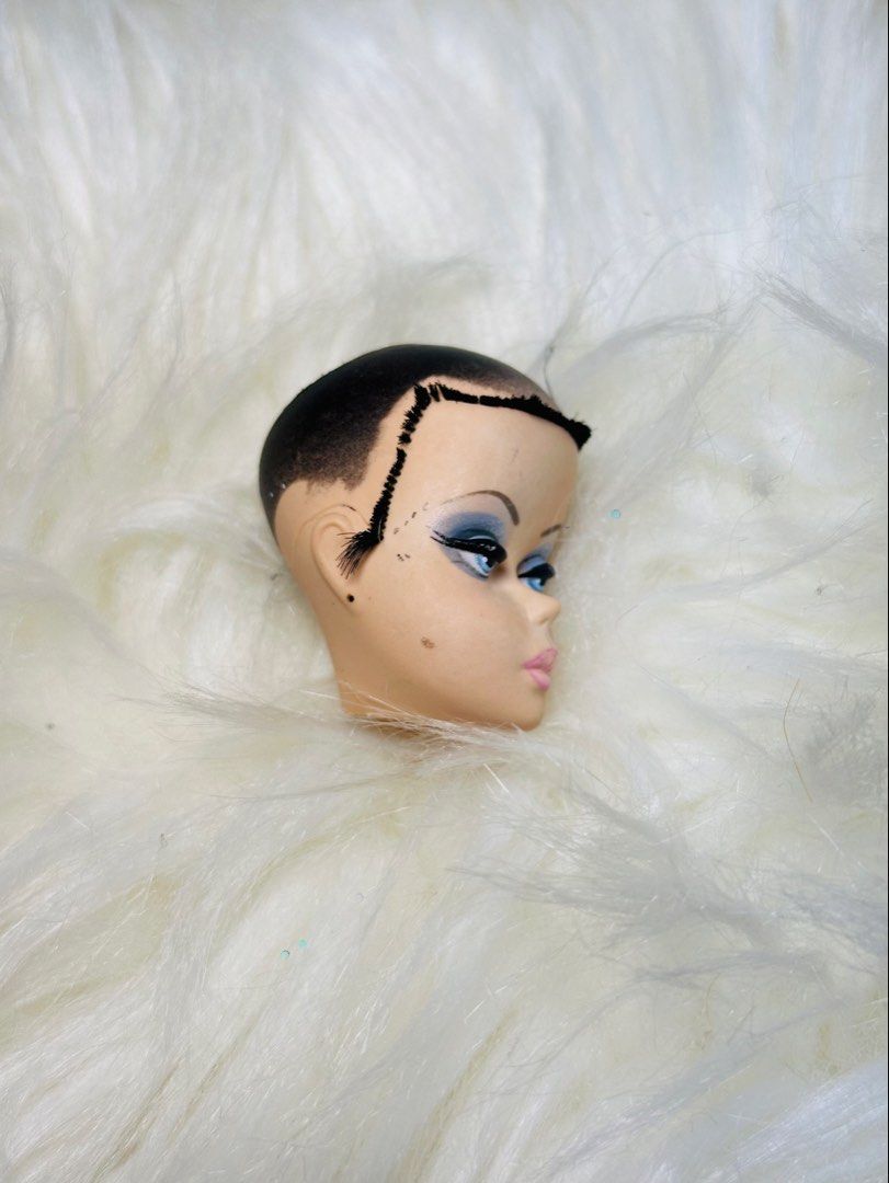 Barbie silkstone head exclusive (Category: Kids Toys) located in Santa Maria. Submitted by houseofluckytoystore (Listing ID 1464751454, Image 2). Description: - Vintage fashion doll head, ideal for custom projects, repairs, or art displays - Features a painted black pixie crop on top with rooted black hair around the sides and back - Striking makeup details including dramatic blue eyeshadow, arched eyebrows, pink lips, and a cheek beauty mark - C