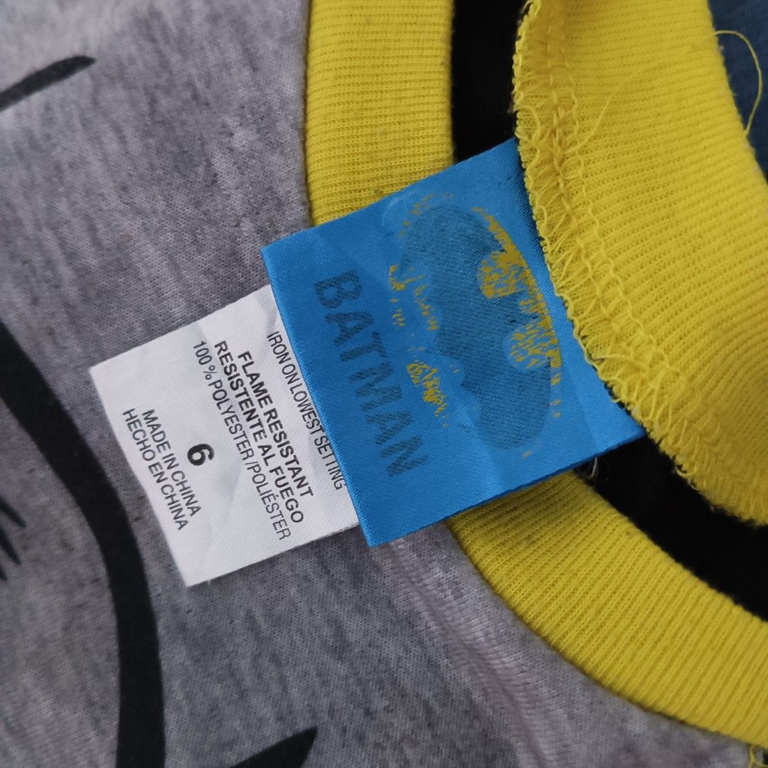 Batman Raglan Long-Sleeve Shirt (Category: Babies & Kids Fashion) located in Subic. Submitted by mustardt_ (Listing ID 1464645305, Image 3). Description: A raglan-style thermal or cotton shirt featuring a gray body, contrasting black long sleeves, a bright yellow crew neckline, and a classic graphic print of Batman's face and cowl. (has stains) size: 14in x 17.5in code: c794.