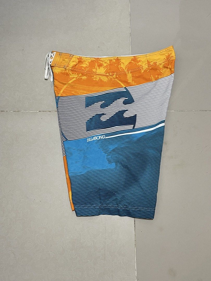 Billabong Board Shorts Size 36 Multicolor Palm Tree Print (Category: Swim Trunks & Board Shorts) located in Manila. Submitted by micoletszx81430 (Listing ID 1464700376, Image 2). Description: - Brand: Billabong - Design: Striking sunset and palm tree print with blue stripes - Size: Tagged 36 (approx. 22 inches in length) - Material: 100% quick-dry polyester - Features: Secure drawstring waist and handy back pocket with flap - Condition: Great for