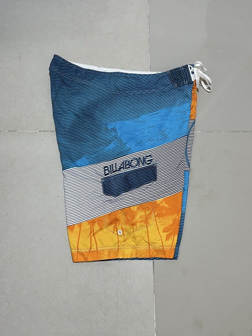 Billabong Board Shorts Size 36 Multicolor Palm Tree Print (Category: Swim Trunks & Board Shorts) located in Manila. Submitted by micoletszx81430 (Listing ID 1464700376, Image 3). Description: - Brand: Billabong - Design: Striking sunset and palm tree print with blue stripes - Size: Tagged 36 (approx. 22 inches in length) - Material: 100% quick-dry polyester - Features: Secure drawstring waist and handy back pocket with flap - Condition: Great for