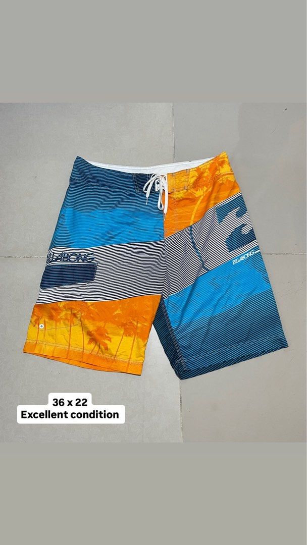 Billabong Board Shorts Size 36 Multicolor Palm Tree Print (Category: Swim Trunks & Board Shorts) located in Manila. Submitted by micoletszx81430 (Listing ID 1464700376, Image 1). Description: - Brand: Billabong - Design: Striking sunset and palm tree print with blue stripes - Size: Tagged 36 (approx. 22 inches in length) - Material: 100% quick-dry polyester - Features: Secure drawstring waist and handy back pocket with flap - Condition: Great for