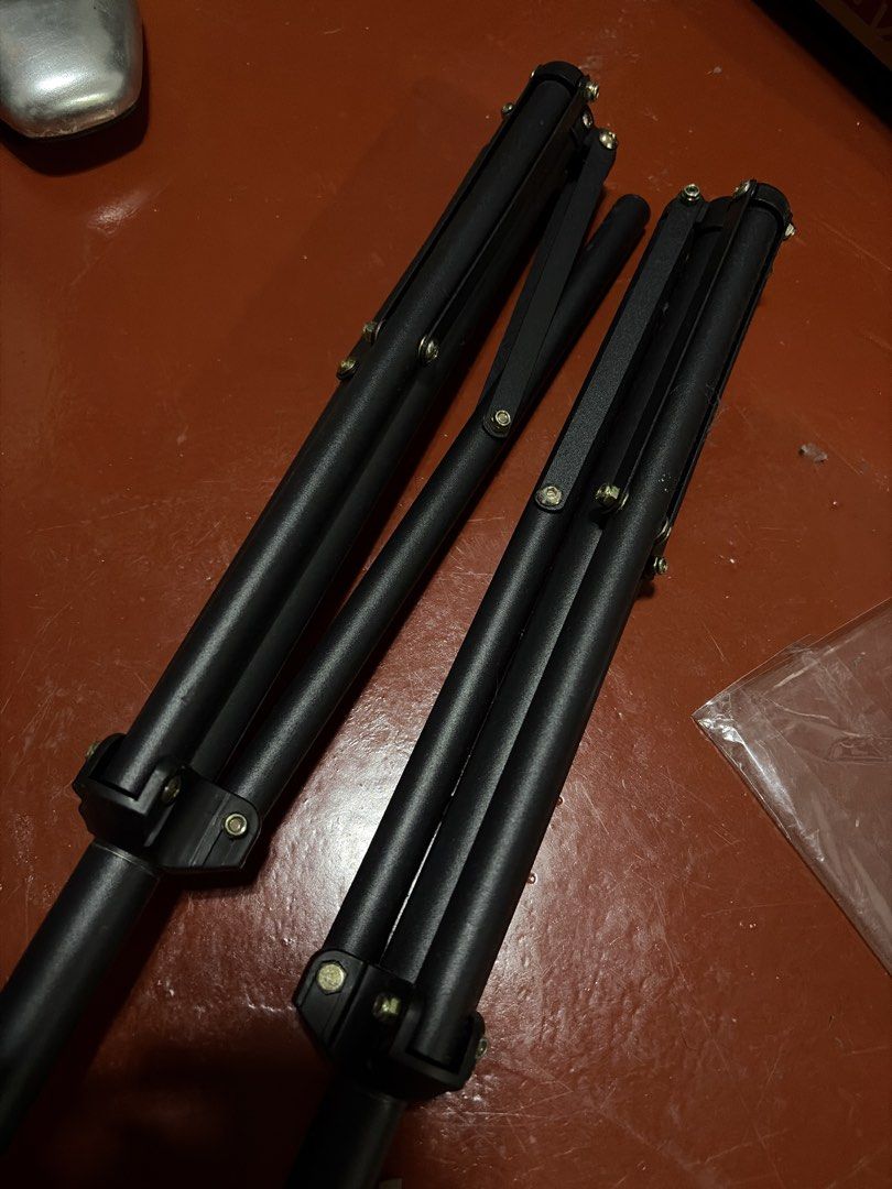 Black adjustable light stands tripod pair (Category: Tripods & Monopods) located in Manila. Submitted by finderskeepersmnl_092026 (Listing ID 1464713166, Image 2). Description: Two black stands, collapsible design. Height adjustable with twist locks. Sturdy metal build, standard mounts at the top. Good for photography lights, flashes, or backdrops. Used a few times, minor scuffs from transport. Ready for studio or field work..