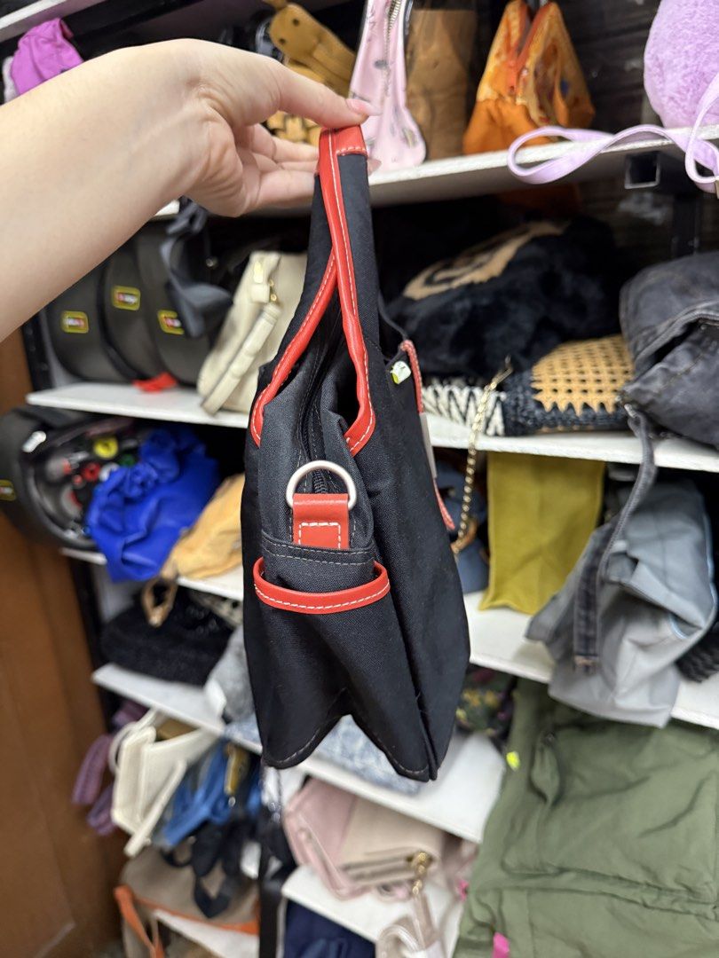 Black and Red Handbag (Category: Tote Bags) located in Manila. Submitted by fastlion.584bdf (Listing ID 1464739443, Image 2). Description: - Color: Black canvas with eye-catching red trim and handles - Storage: Double zippered main compartments with multiple interior pockets - Details: Chic metal plaque on the front vertical strap - Size: Compact and lightweight, ideal for everyday use - Condition: Clean interior, well-maintained.