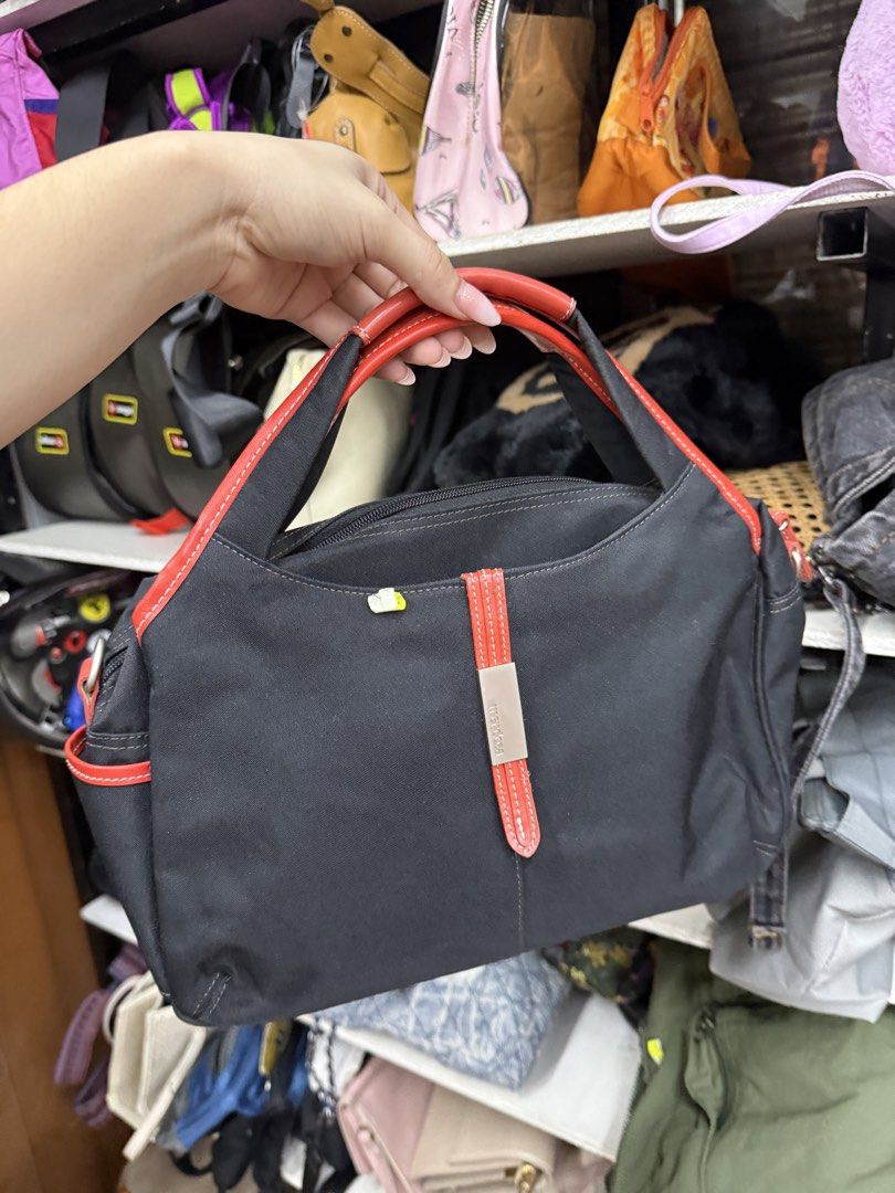 Black and Red Handbag (Category: Tote Bags) located in Manila. Submitted by fastlion.584bdf (Listing ID 1464739443, Image 1). Description: - Color: Black canvas with eye-catching red trim and handles - Storage: Double zippered main compartments with multiple interior pockets - Details: Chic metal plaque on the front vertical strap - Size: Compact and lightweight, ideal for everyday use - Condition: Clean interior, well-maintained.