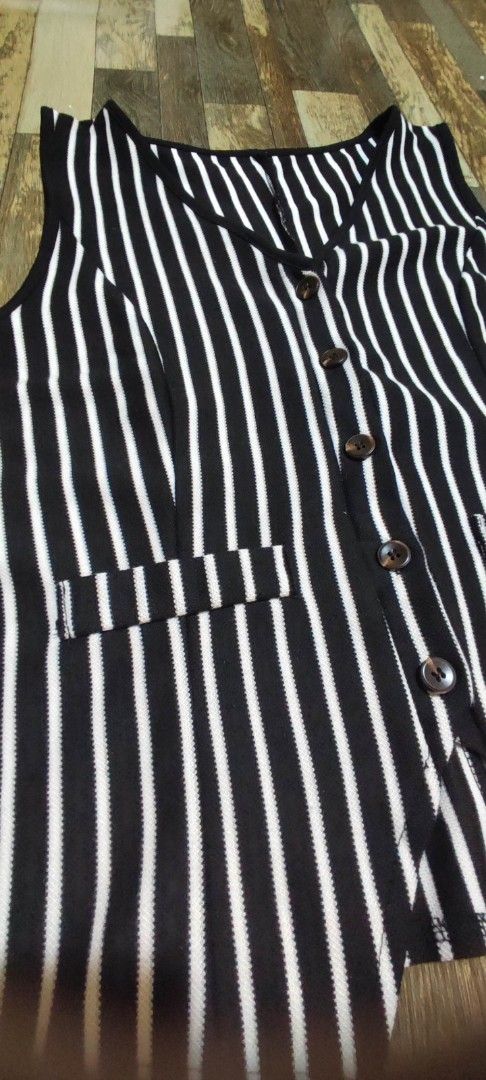 Black and White Striped Sleeveless Vest (Category: Sleeveless) located in Quezon City. Submitted by tintinarms (Listing ID 1464621994, Image 2). Description: - Classic black and white stripe pattern - Sleeveless vest design - Two functional front pockets - Button-down closure - Slightly cropped cut - Ideal for layering over tops or dresses - Versatile for smart casual outfits.