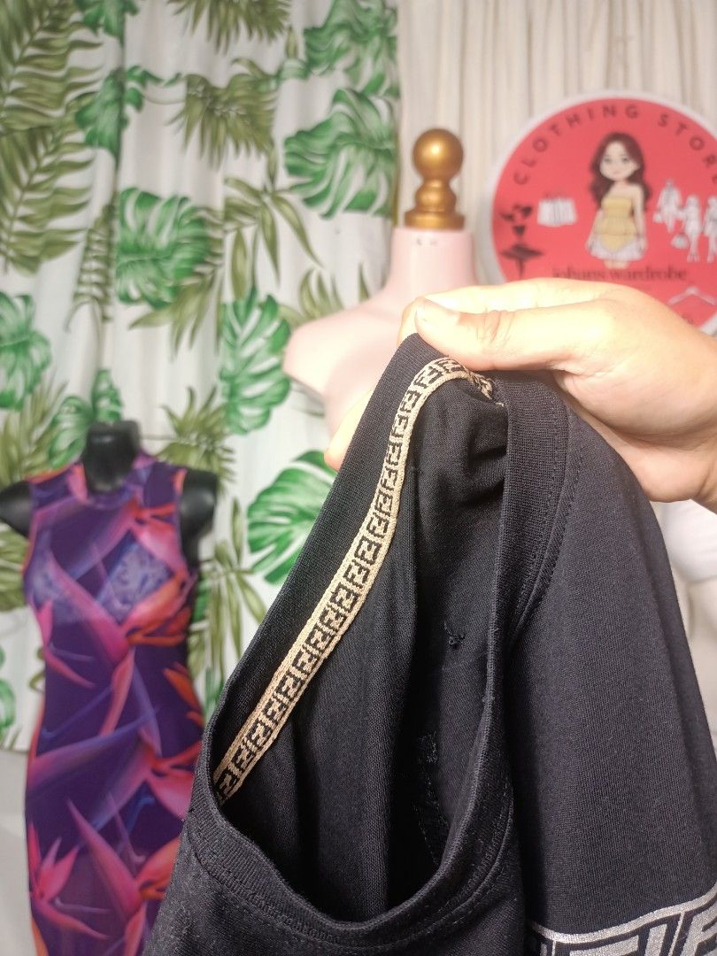 Black Graphic Tee with Designer Monogram Details (Category: Shirts) located in Manila. Submitted by johans9 (Listing ID 1464692941, Image 3). Description: - Color: Classic Black - Material: 100% Cotton body with ribbed trim blend - Origin: Made in Portugal - Fit: Relaxed fit with short sleeves - Design: Bold front graphic print with unique patterned detailing on the inner neckline - Condition: Clean and ready to wear.
