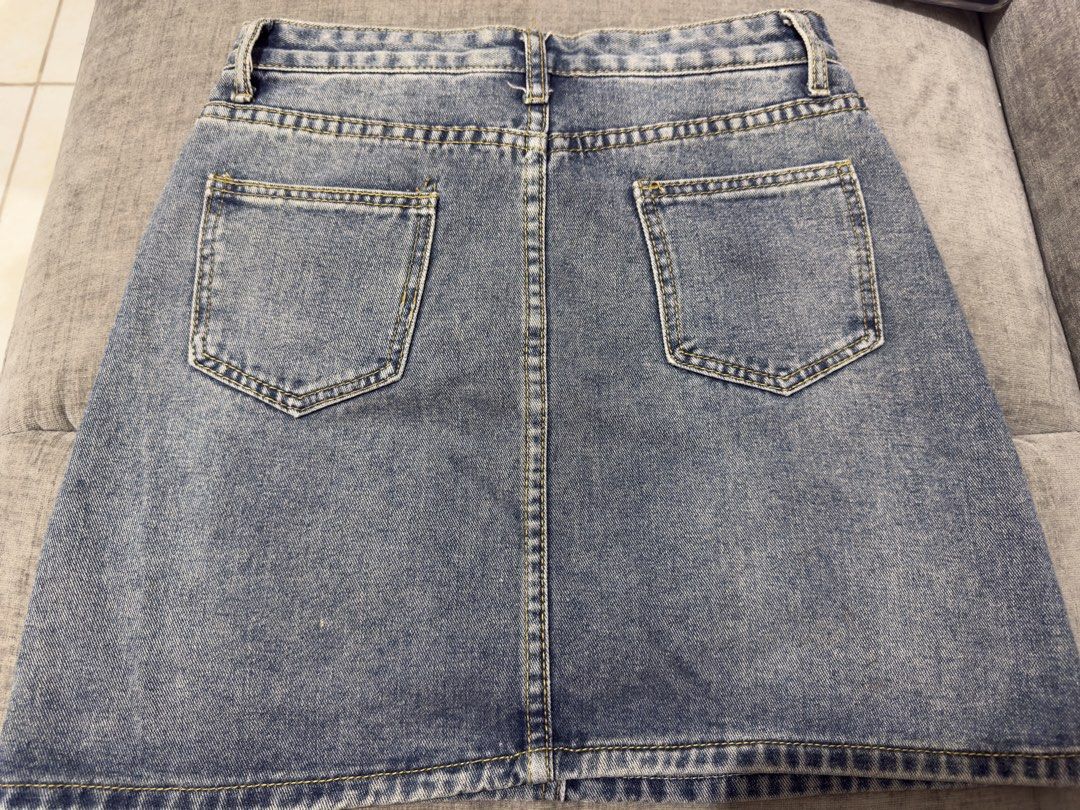 Blue Denim Mini Skirt (Category: Skirts) located in Taguig. Submitted by marietimebiscuit (Listing ID 1464725340, Image 2). Description: Blue denim mini skirt with a classic acid-wash finish. Front button closure and belt loops included. Features two front pockets and two back patch pockets. Contrast yellow stitching throughout. Straight cut silhouette that pairs easily with tees and crop tops..