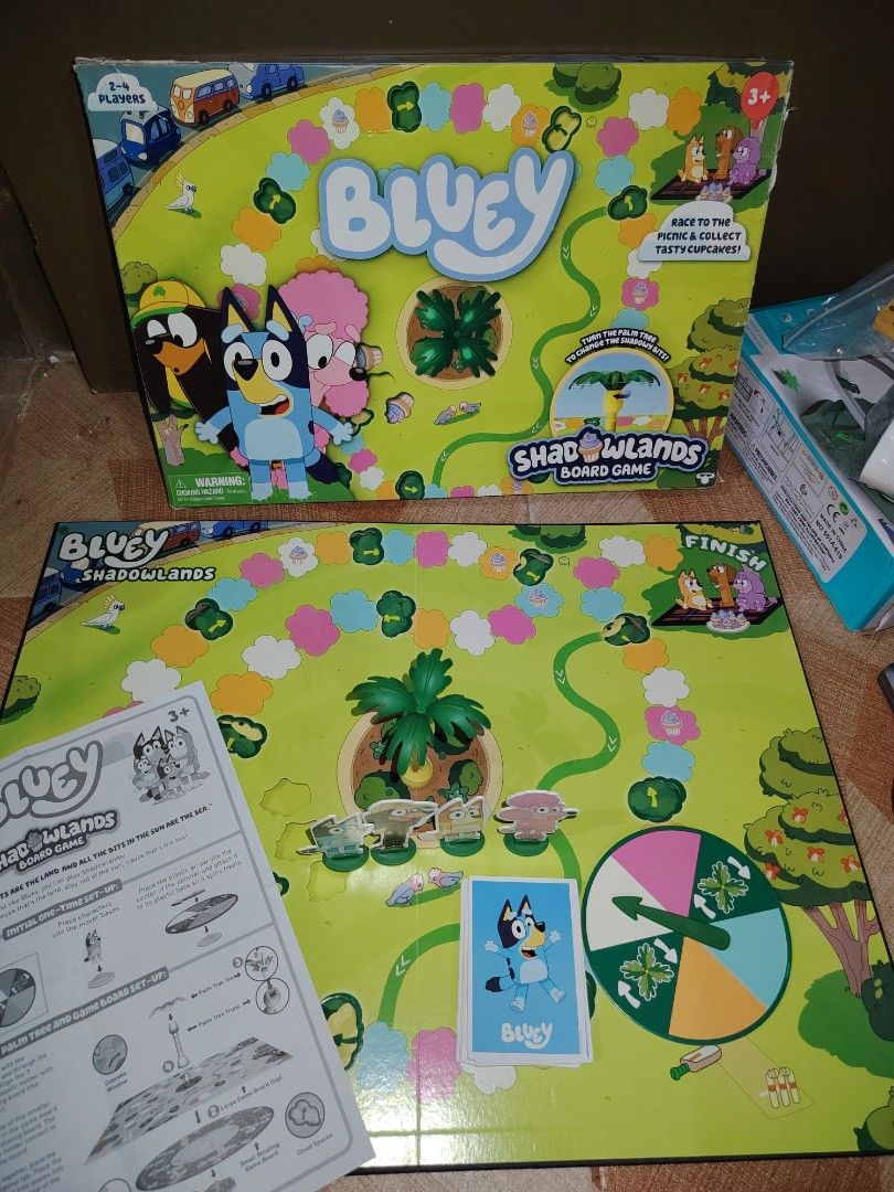 Bluey Shadowlands Board Game for 2-4 Players (Category: Board Games & Puzzles) located in Santiago. Submitted by aceheart0118672 (Listing ID 1464647561, Image 1). Description: - Bluey Shadowlands Board Game - Fun for 2-4 players - Includes: game board, character pawns, spinner, and cards - Objective: Race to the finish and collect tasty cupcakes! - Perfect for family game nights - All pieces accounted for.