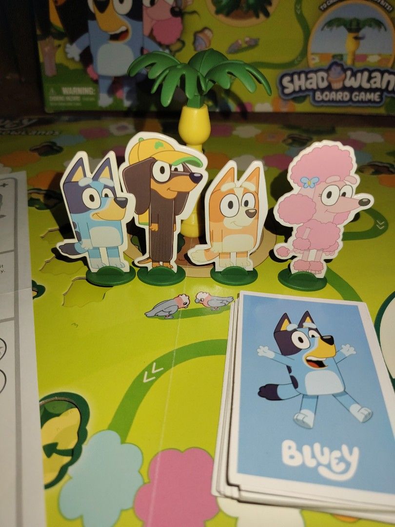 Bluey Shadowlands Board Game for 2-4 Players (Category: Board Games & Puzzles) located in Santiago. Submitted by aceheart0118672 (Listing ID 1464647561, Image 2). Description: - Bluey Shadowlands Board Game - Fun for 2-4 players - Includes: game board, character pawns, spinner, and cards - Objective: Race to the finish and collect tasty cupcakes! - Perfect for family game nights - All pieces accounted for.