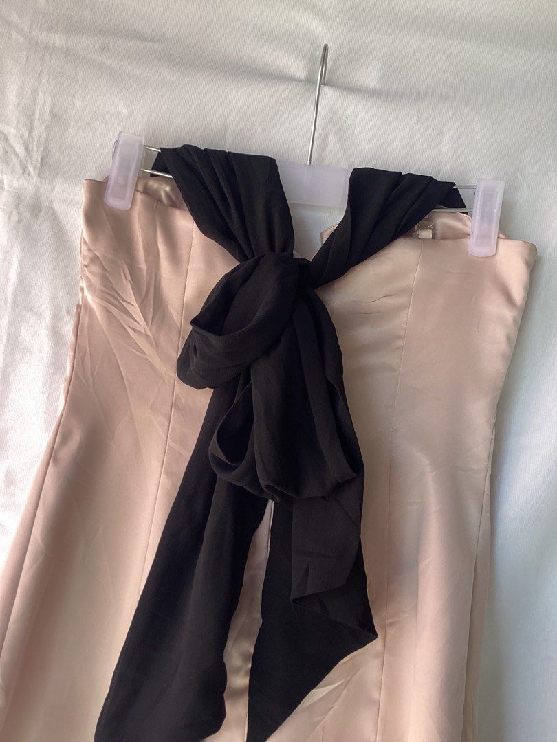 Blush satin dress S-M (Category: Dresses) located in Iloilo. Submitted by getnagetch (Listing ID 1464703190, Image 2). Description: - Color: Soft blush pink with contrasting black details - Size: S-M - Material: Smooth satin fabric with a slight sheen - Design: Clean lines, simple flared silhouette, and a chic bow accent at the bust - Occasion: Ideal for dinner dates, parties, and formal events - Condition: Ready to wear.