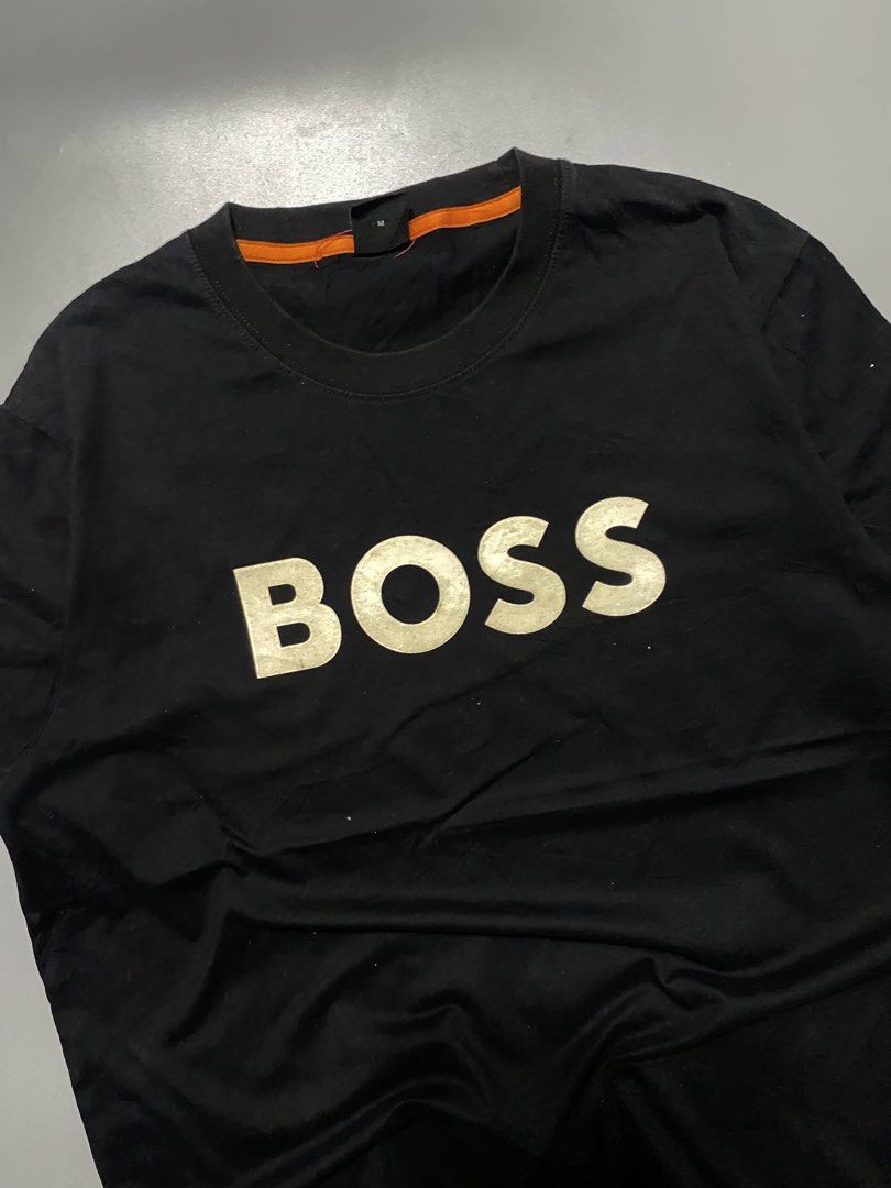 BOSS Black T-Shirt with White Logo (Category: Tshirts & Polo Shirts ) located in Silang. Submitted by kenneth_ukays (Listing ID 1464577509, Image 2). Description: - Classic black t-shirt from BOSS - Iconic white BOSS logo printed across the chest - Comfortable and stylish for everyday wear - Tagged size Medium (M) - Unique orange accent on the inner collar.