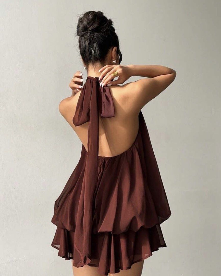 Brown Chiffon Halterneck Mini Dress (Category: Dresses) located in Manila. Submitted by paragon.attic (Listing ID 1464748226, Image 2). Description: - Color: Deep brown - Material: Lightweight, textured chiffon - Design: Halter neck with open back and long trailing tie straps - Top: Balloon-style gathered bodice - Bottom: Tiered ruffled mini skirt - Fit: Flowy, comfortable, and breezy.