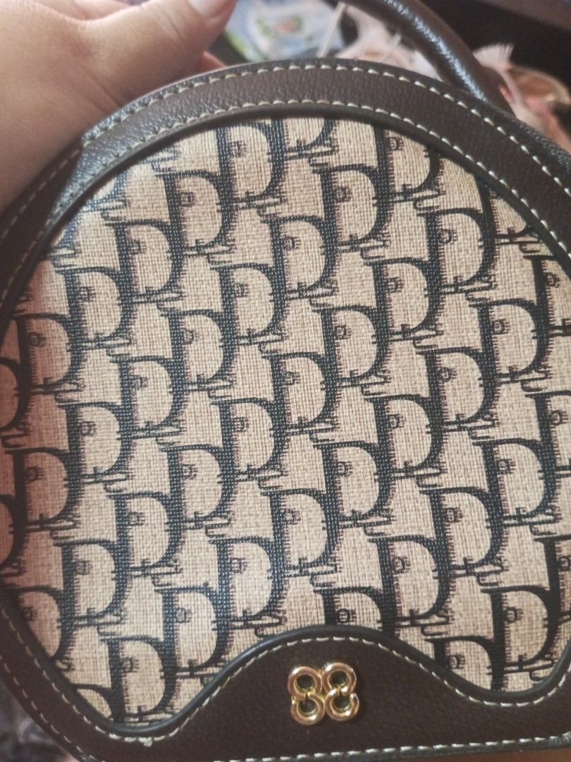 Brown Monogram Round Handbag with Strap (Category: Luxury Bags & Wallets) located in Manila. Submitted by maritanaai22557 (Listing ID 1464605764, Image 1). Description: - Cute round handbag in brown - Classic monogram pattern on the front - Top handle and long adjustable strap - Zipper closure - Interior small pocket - Brand: DUOSTO - Ideal for everyday use.