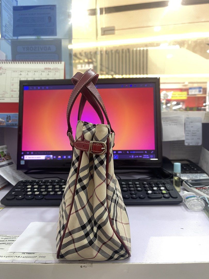 Burberry Handbag (Category: Shoulder Bags) located in Manila. Submitted by fionaret (Listing ID 1464699846, Image 2). Description: - Authentic Burberry Handbag design - Iconic check pattern canvas - Maroon leather handles and trim accents - Structured silhouette with secure top closure - Great addition to any casual or chic outfit.