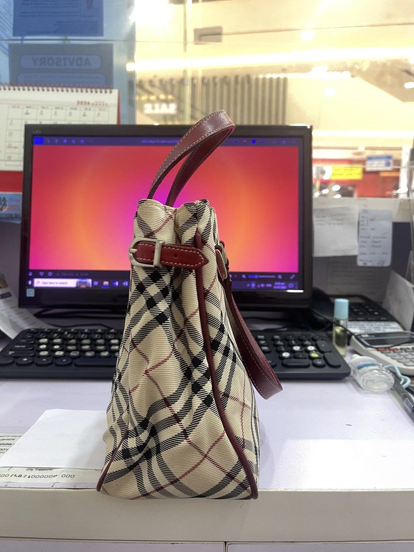 Burberry Handbag (Category: Shoulder Bags) located in Manila. Submitted by fionaret (Listing ID 1464699846, Image 3). Description: - Authentic Burberry Handbag design - Iconic check pattern canvas - Maroon leather handles and trim accents - Structured silhouette with secure top closure - Great addition to any casual or chic outfit.