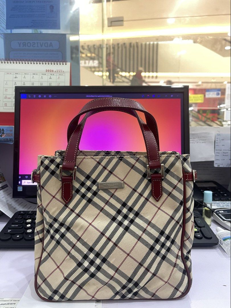 Burberry Handbag (Category: Shoulder Bags) located in Manila. Submitted by fionaret (Listing ID 1464699846, Image 1). Description: - Authentic Burberry Handbag design - Iconic check pattern canvas - Maroon leather handles and trim accents - Structured silhouette with secure top closure - Great addition to any casual or chic outfit.