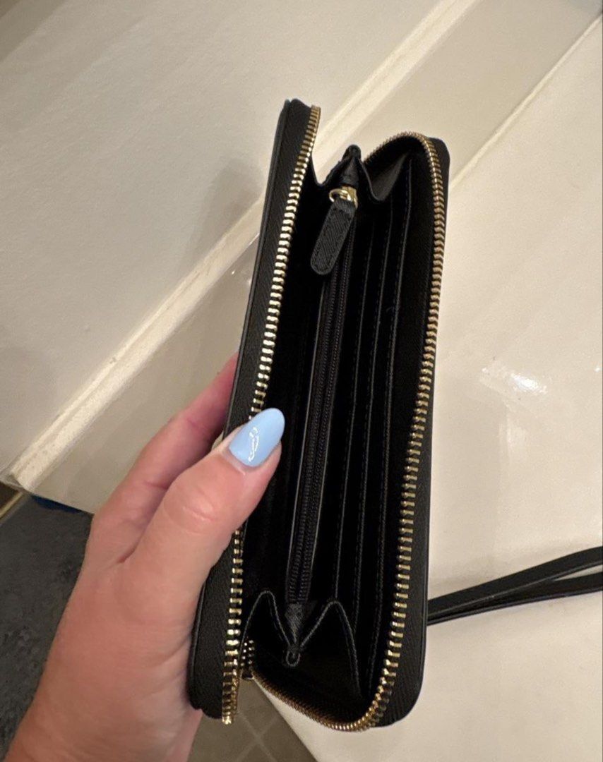 Calvin Klein Black Zip Around Wristlet Wallet (Category: Wallets & Card holders) located in Manila. Submitted by kaia_studios (Listing ID 1464702789, Image 3). Description: - Brand: Calvin Klein - Color: Classic Black with elegant Gold hardware and lettering - Material: Durable textured faux leather - Closure: Secure zip-around design - Features: Detachable wrist strap for versatile styling - Interior: Multiple card slots, slip compartments, and 