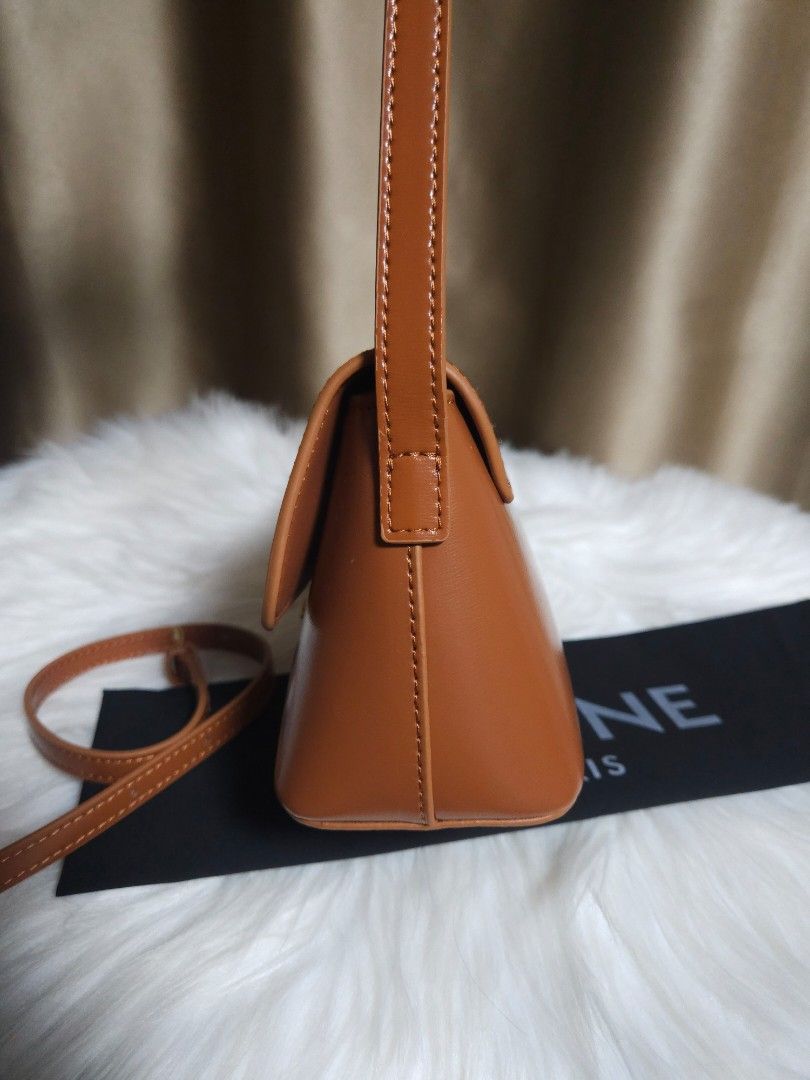 Celine Triomphe Bag Tan Leather (Category: Luxury Bags & Wallets) located in Manila. Submitted by sulit.deal (Listing ID 1464650629, Image 3). Description: - Japan Sourced - tan leather Celine crossbody bag - Features iconic gold Triomphe clasp - Adjustable strap for comfortable wear - Comes with original Celine dust bag - Versatile for daily use or special occasions - A timeless classic that complements any outfit.