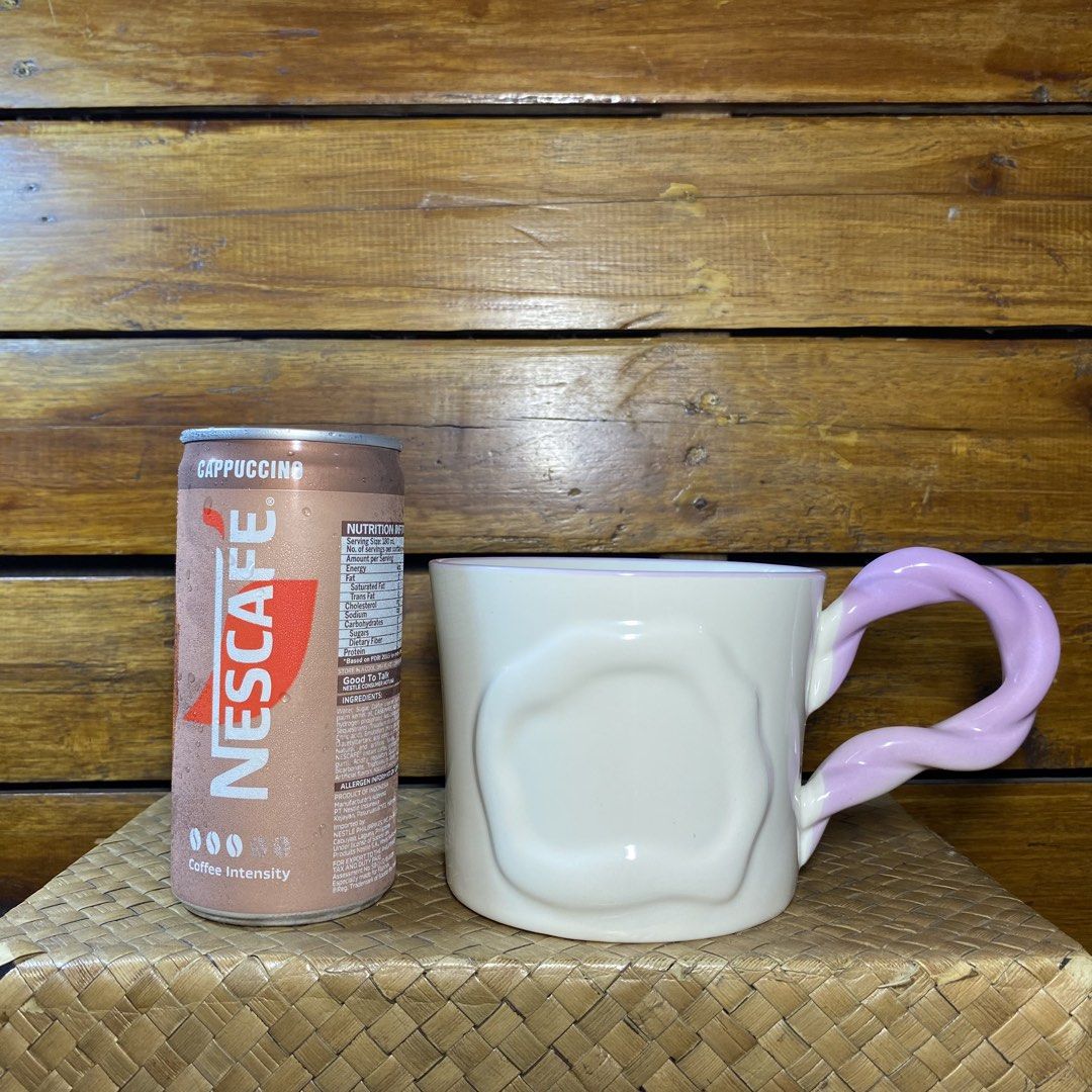 Ceramic Mug with Twisted Handle (Category: Coffee & Tea Tableware) located in Quezon City. Submitted by oliviararo46032 (Listing ID 1464670480, Image 2). Description: - Cream-colored mug with a unique wavy texture. - Features a fun, twisted pastel purple handle. - Subtle light purple trim around the rim. - Ideal for your morning coffee or tea. - Adds a playful touch to your kitchenware..