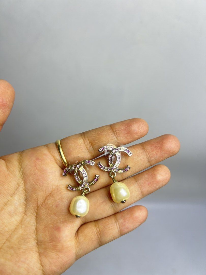 Chanel CC Logo Crystal Pearl Dangle Earrings (Category: Earrings) located in Baguio. Submitted by chiechie1234 (Listing ID 1464689322, Image 2). Description: - Brand: Chanel - Design: CC logo with pink crystals and dangling faux pearls - Hardware: Gold-tone - Details: Hallmark stamp on the back, secure post back closure with plastic backs - Condition: Clean, all crystals fully intact .