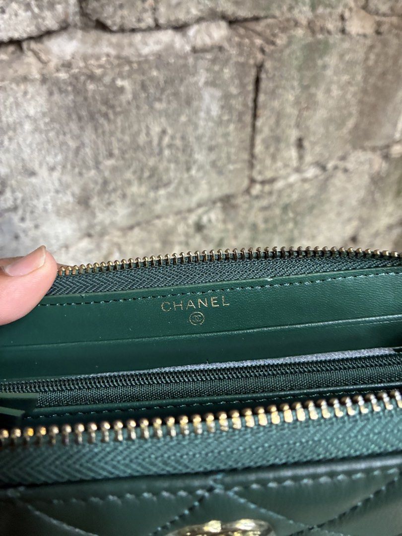 Chanel Quilted Green Leather Zip Wallet (Category: Wallets & Card holders) located in Manila. Submitted by assortedgoodsv3 (Listing ID 1464764702, Image 3). Description: - Brand: Chanel - Material: Dark green quilted leather - Hardware: Gold-tone with iconic CC logo - Closure: Secure zip-around - Interior: Multiple card slots, slip pockets, and zippered coin compartment - Inclusions: Original black storage box and white dust bag - Condition: Clea